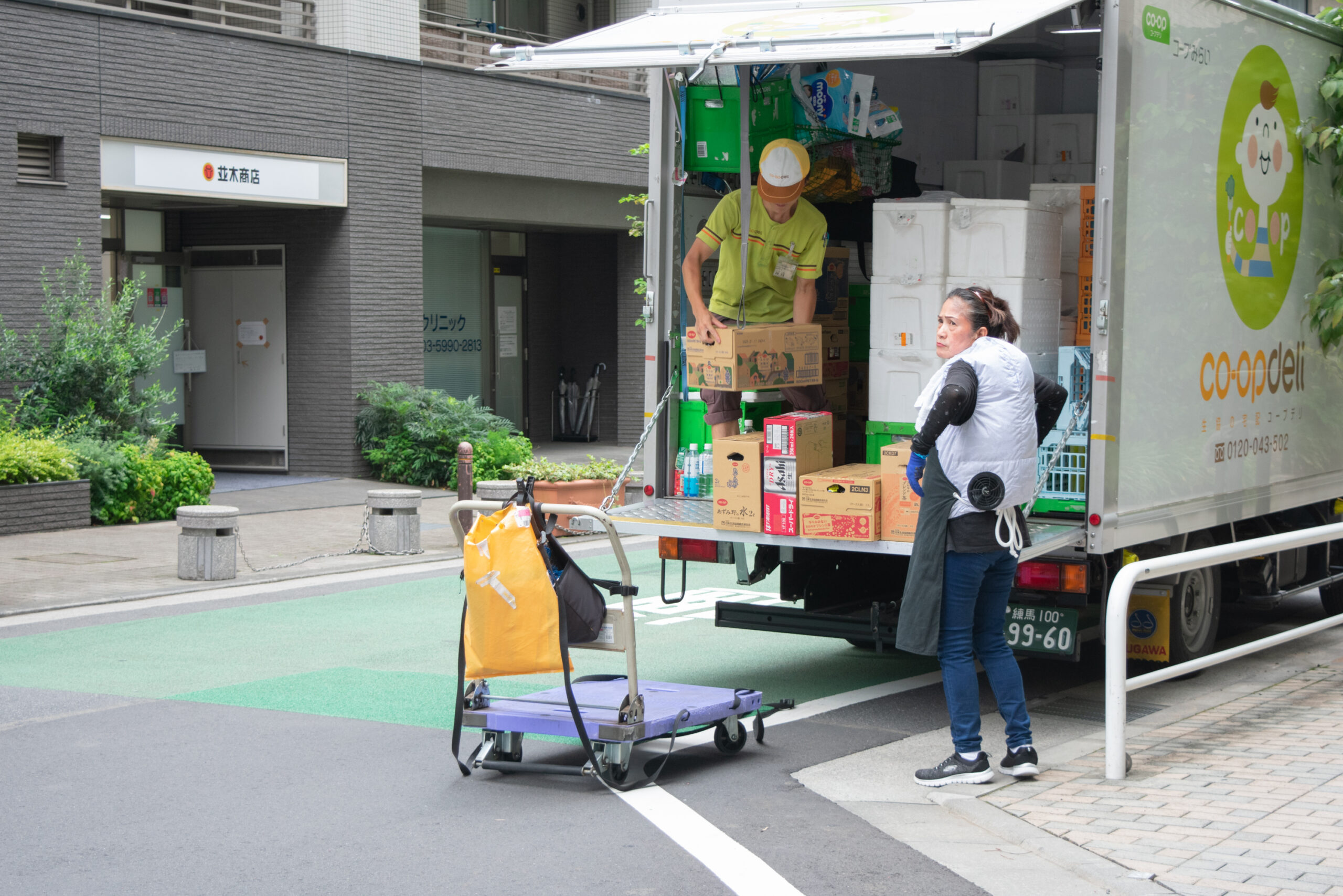 Delivery workers unload boxes in Wakaba in Tokyo's Shinjuku Ward on Aug. 21